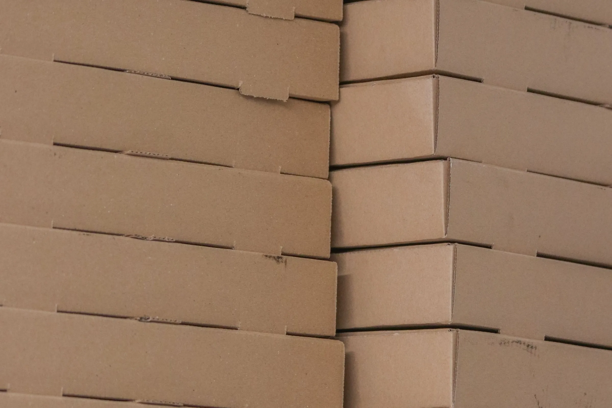 Plain brown die-cut cartons stacked in two neat columns.