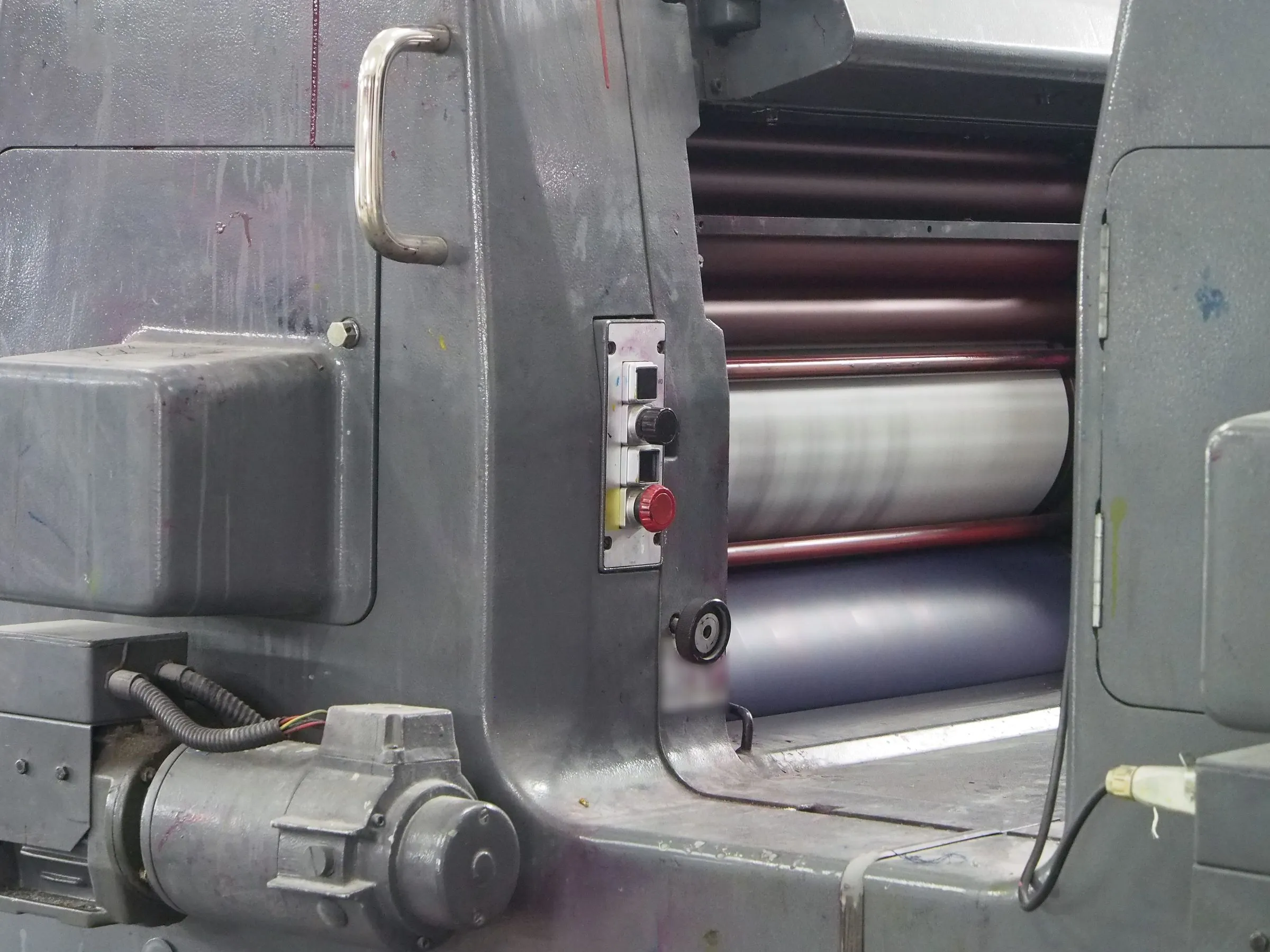 Side frame of a sheet-fed printing press with its inking rollers turning.